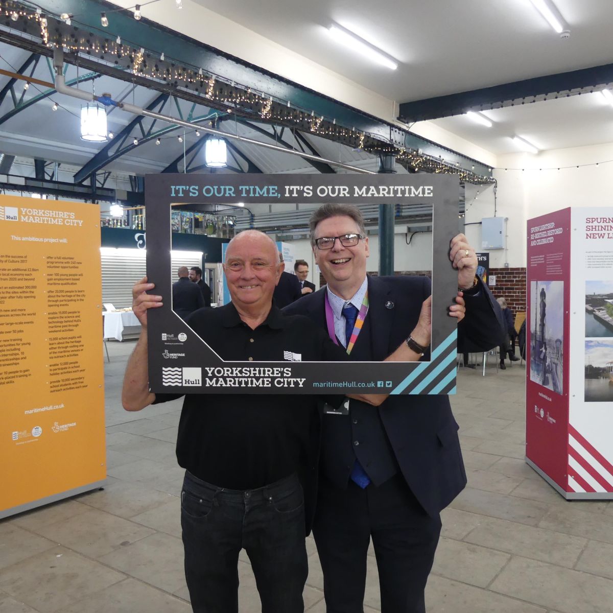 Project director and exhibition specialist pose in the frame at exhibition launch