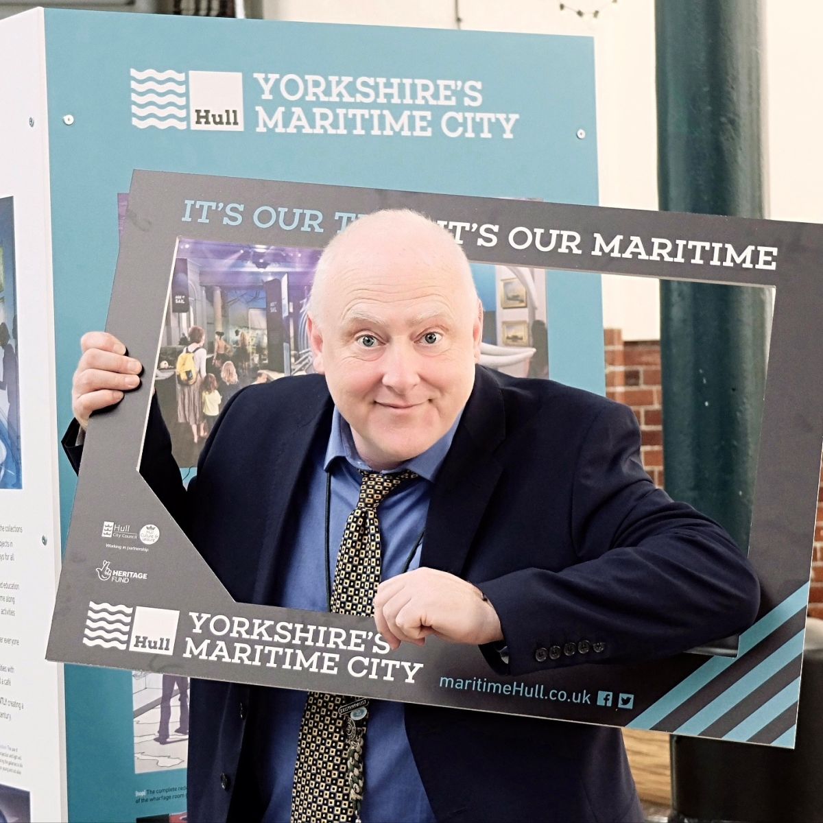 Programme Manager poses in the frame at Exhibition Launch