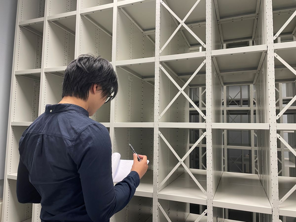 Documentation Assistant Jason looks at plans ready for the collection returning