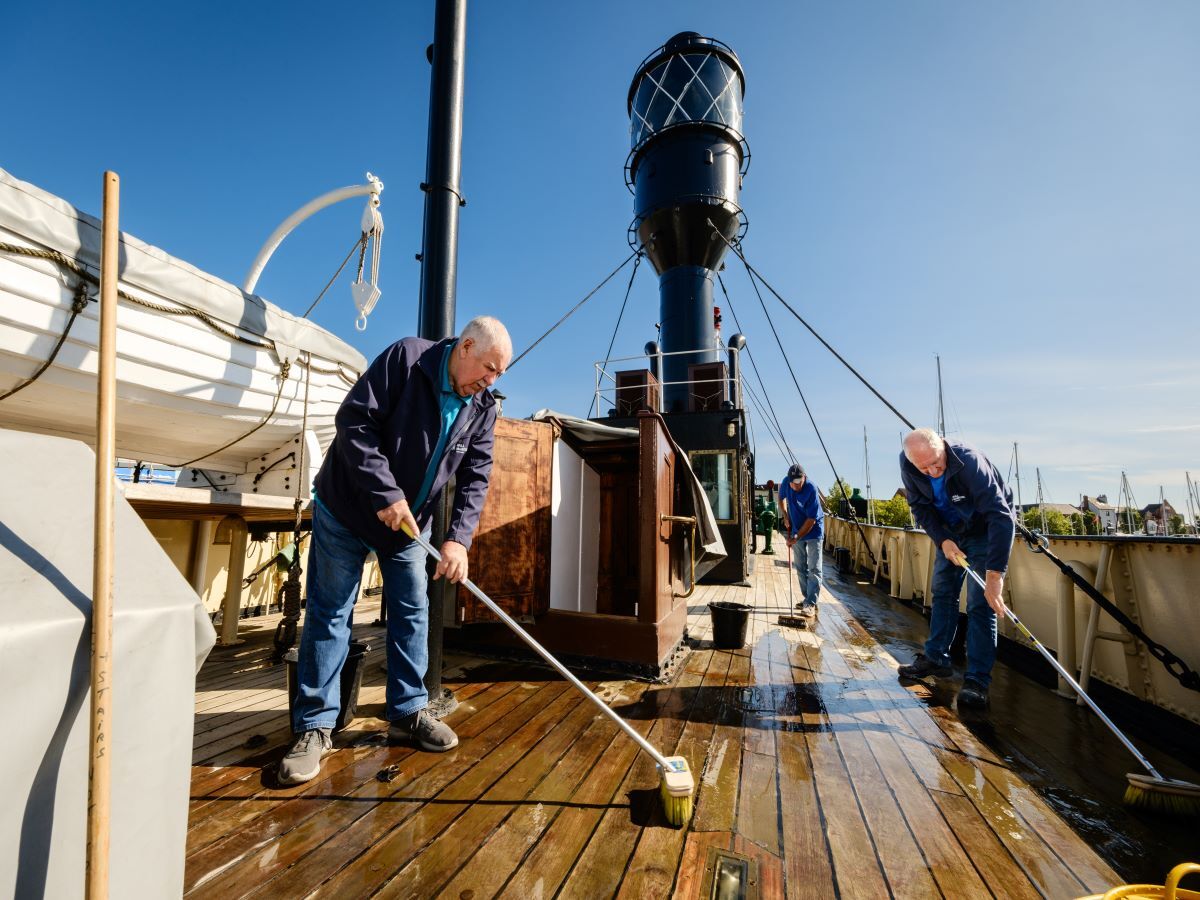 Volunteers swab the deck